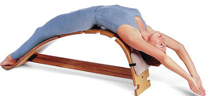 Woman stretching on The Whale therapeutic back stretching bench, deep spinal stretch posture correction device