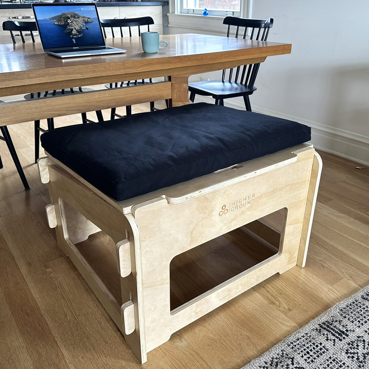 Wooden active sitting chair with black cushion on adjustable angled platform design