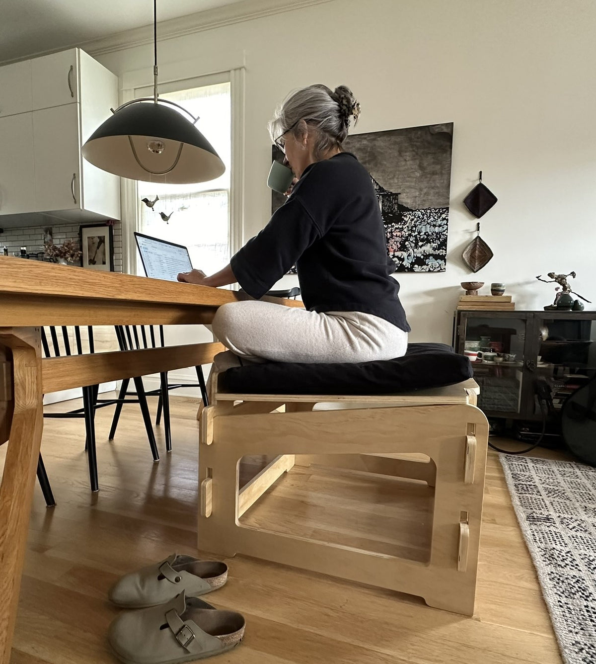 Side view of active sitting chair supporting upright posture while working at a desk