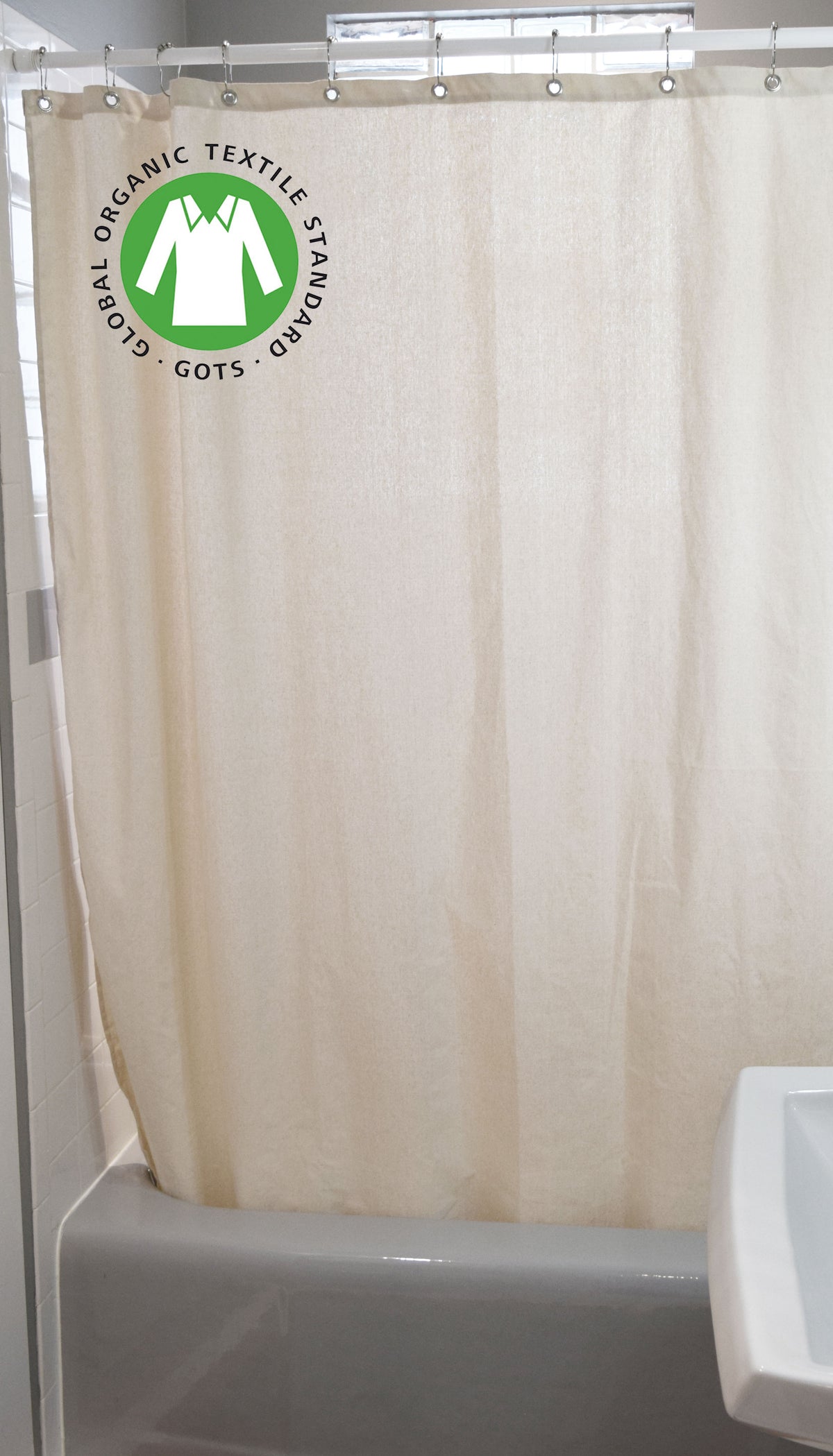 Beige organic cotton shower curtain styled over bathtub