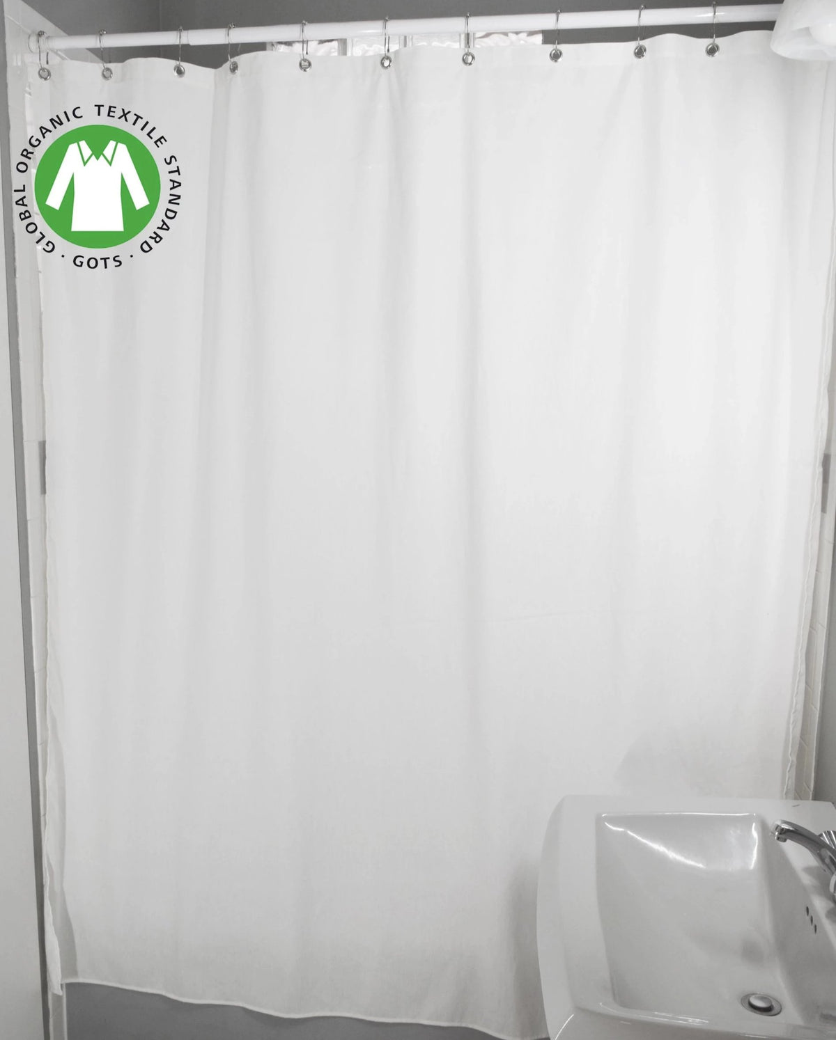 White organic cotton shower curtain styled in minimalist bathroom