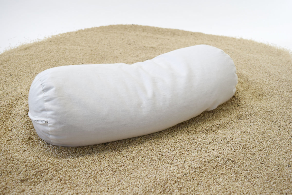 Buckwheat hull bolster pillow showing organic filling material and ergonomic shape