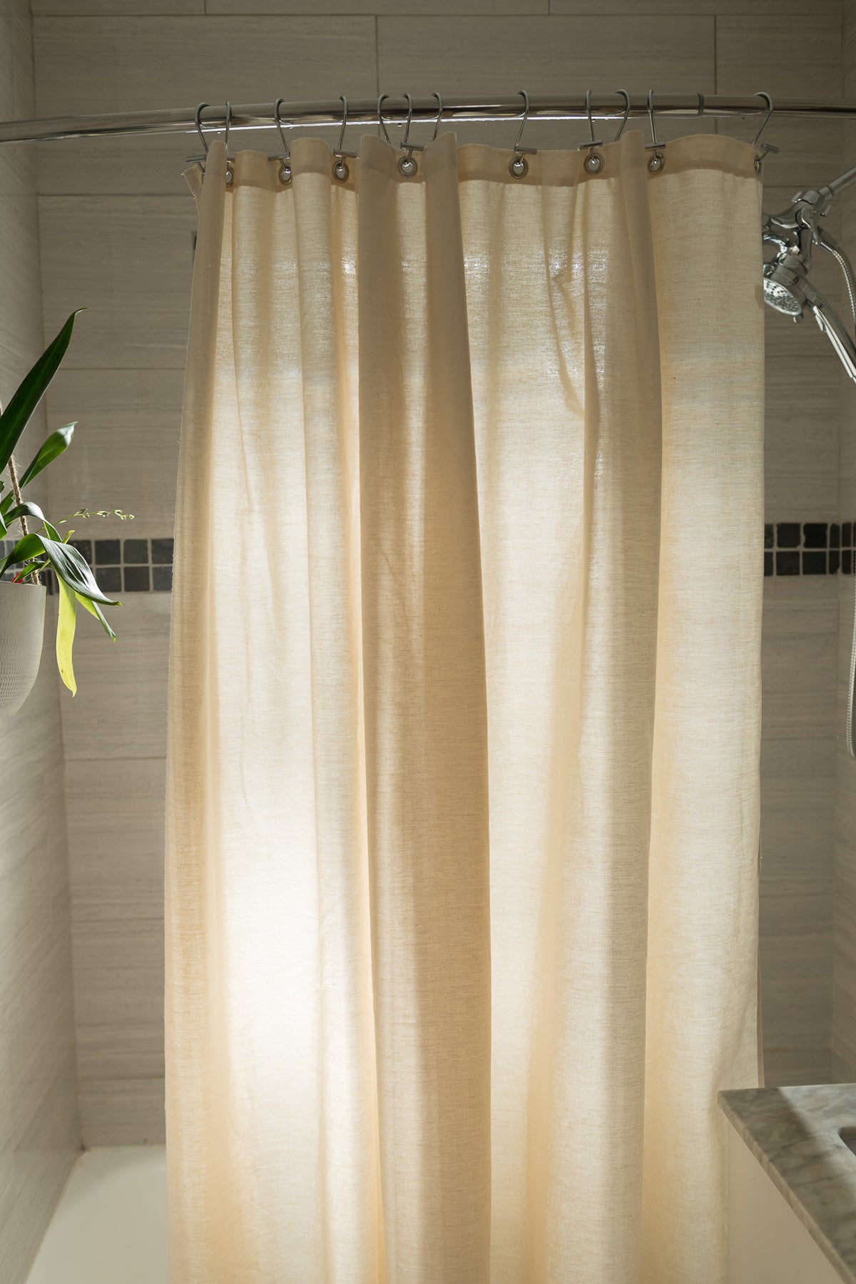Natural beige organic cotton shower curtain in bright bathroom setting