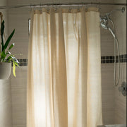 Natural cotton shower curtain in beige installed on bathtub with chrome rod, soft linen look fabric