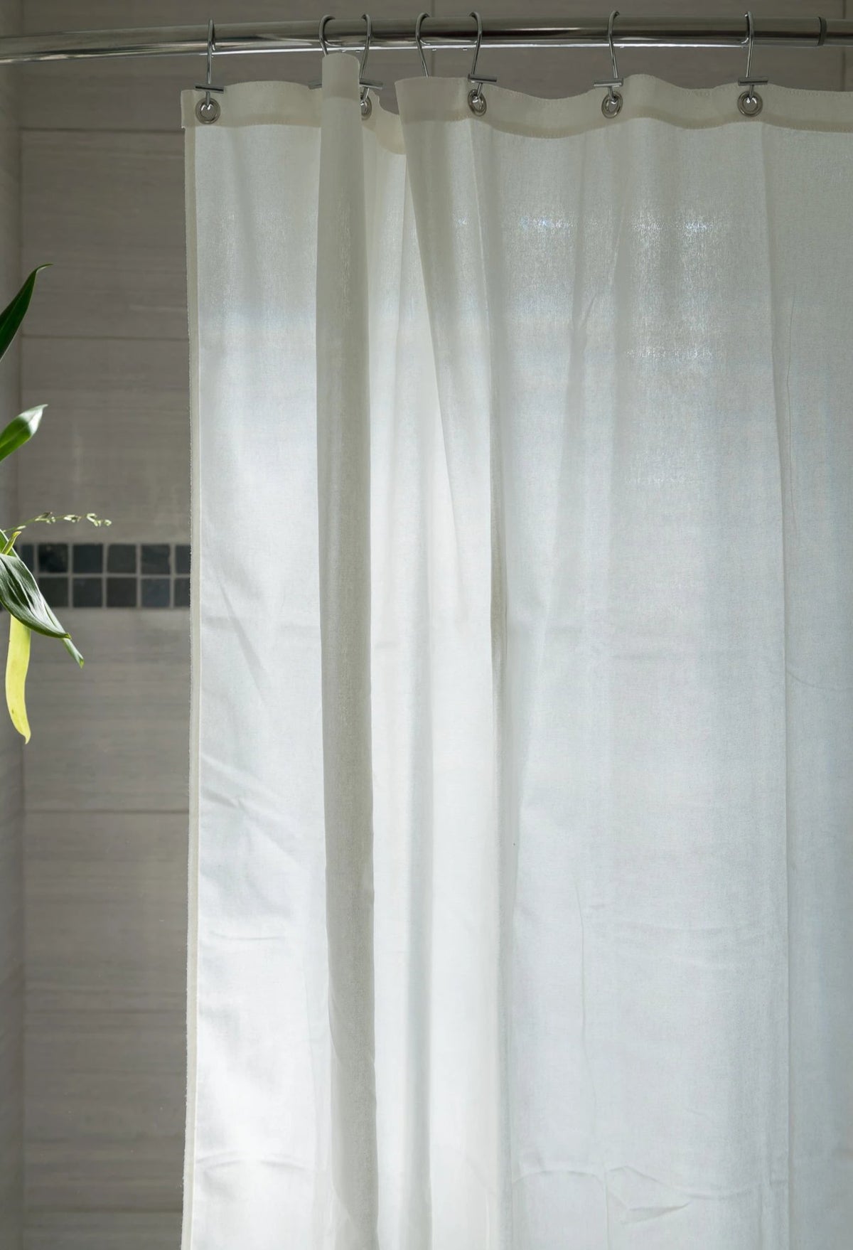 White cotton shower curtain hanging straight, minimalist bathroom style