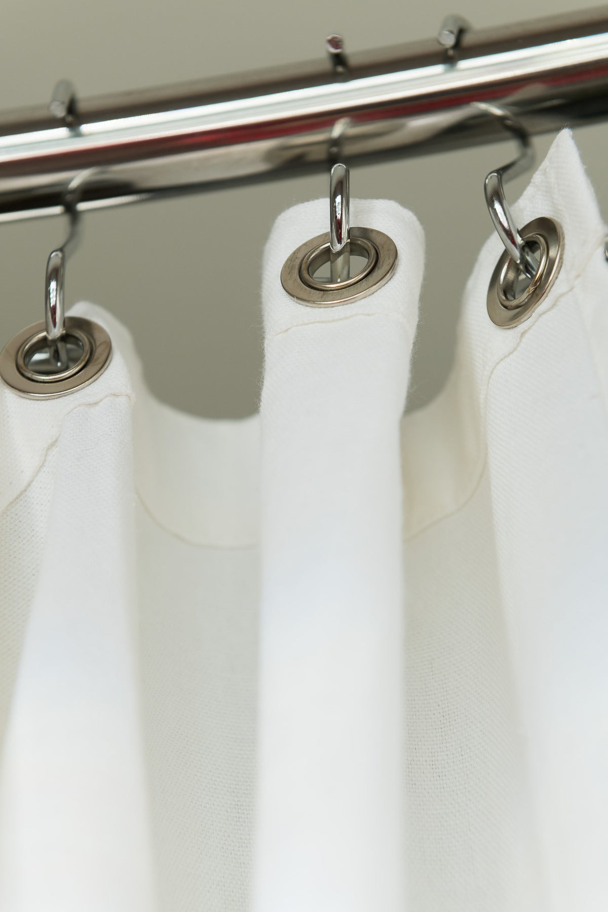 Shower curtain hooks attached to chrome rod, sturdy metal ring detail