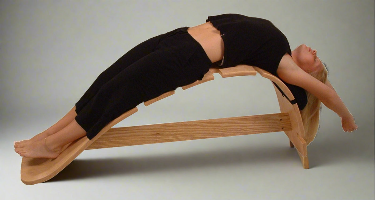 Women using a whale stretching bench for the supported bridge pose, enhancing flexibility and relieving lower back tension
