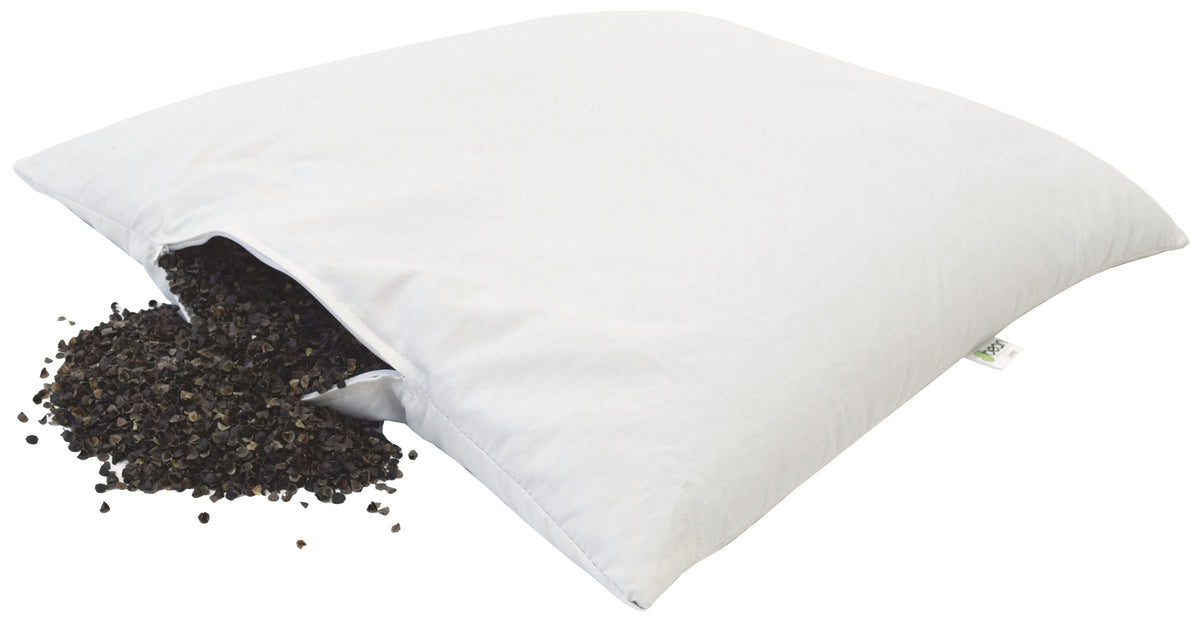 White pillow with buckwheat hulls spilling showing natural fill