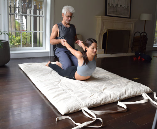 man stretching young woman on thai shiatsu cotton massage mat