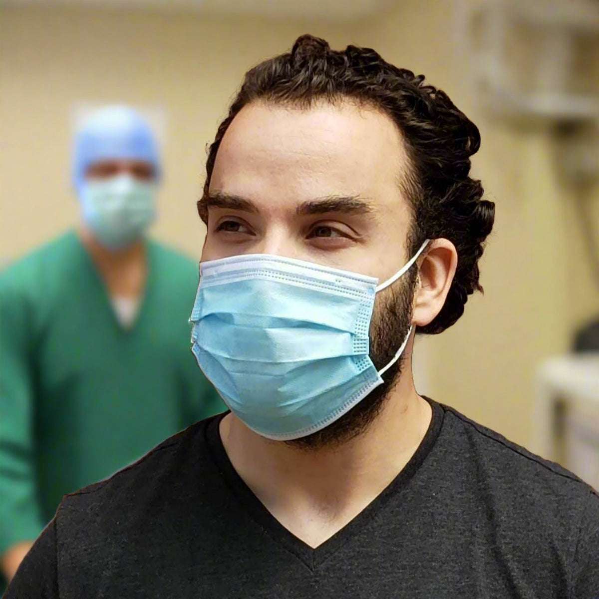 Bulk 3 ply disposable face mask worn by a man, breathable pleated design with ear loops for daily protection