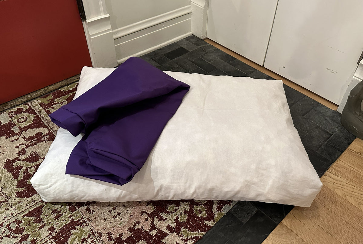 Dog bed with light gray cover and purple inner liner showing removable foam insert