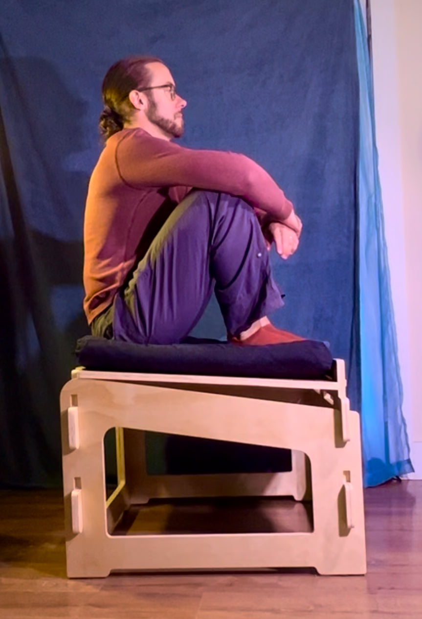 Side profile of person sitting on adjustable meditation stool