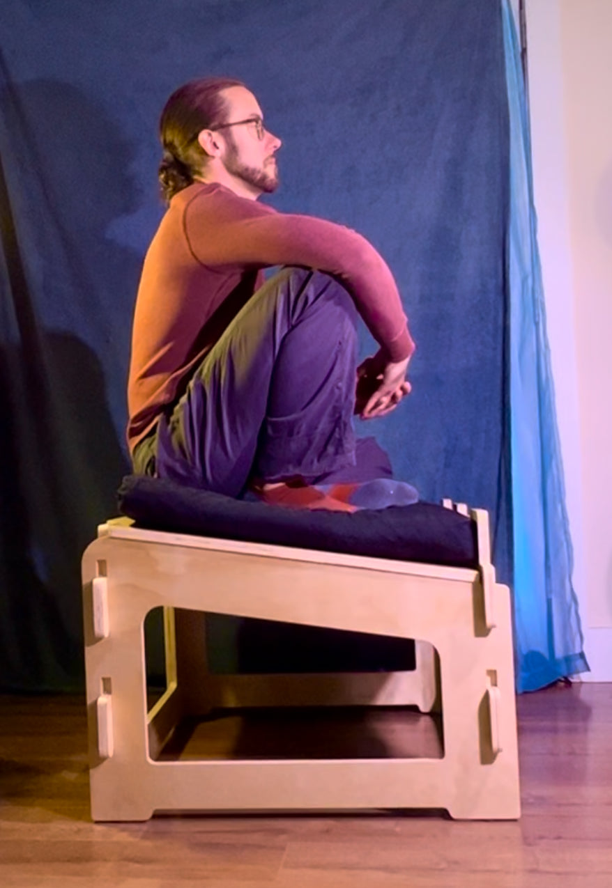 Person demonstrating ergonomic meditation posture on sitting platform