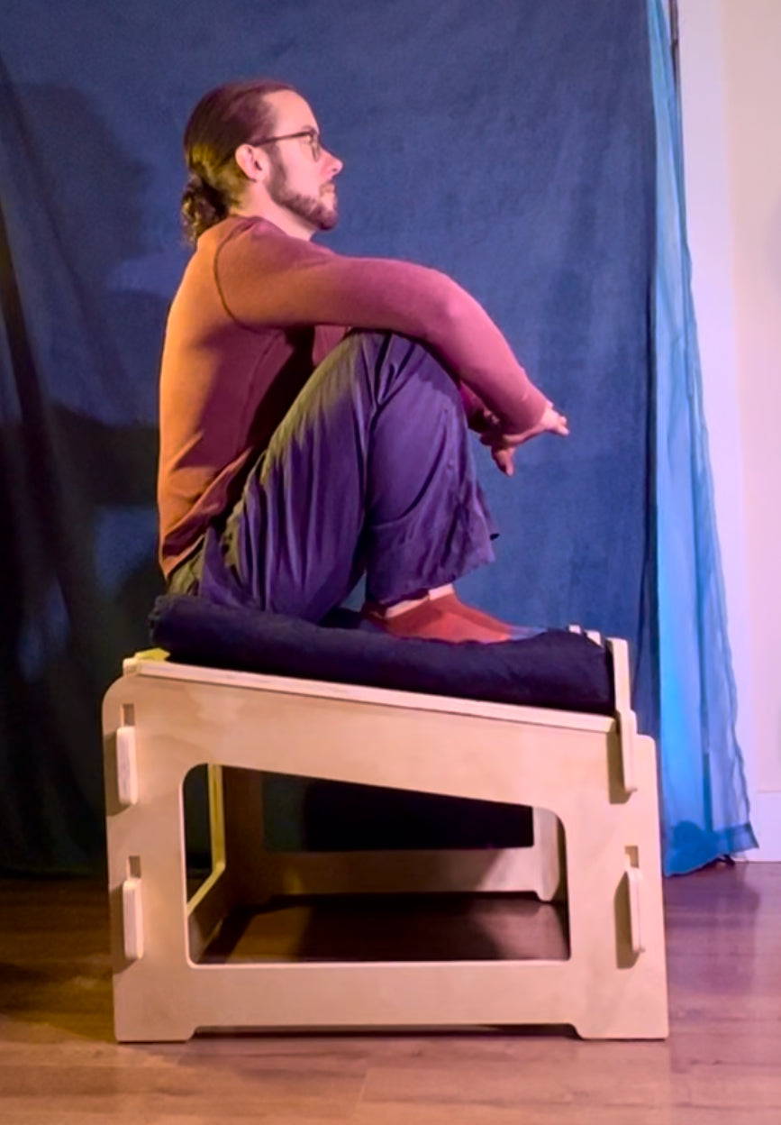 Person demonstrating ergonomic meditation posture on sitting platform