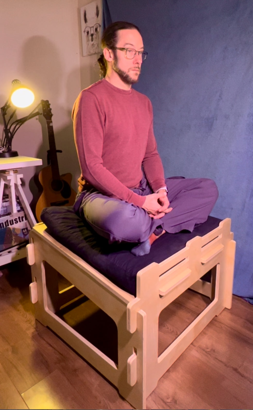 Person demonstrating ergonomic meditation posture on sitting platform
