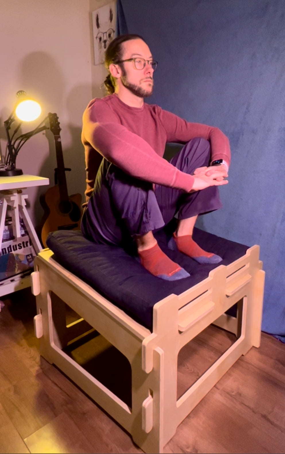 Person demonstrating ergonomic meditation posture on sitting platform