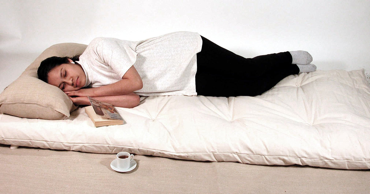 Woman resting on a soft 100% organic cotton floor mat cushion used as a comfortable floor mattress for relaxation and lounging