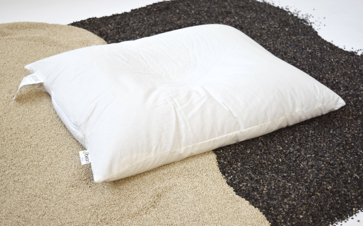 White organic pillow placed on buckwheat hulls highlighting natural fill material and firmness