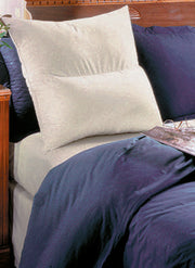 Comfort Reading Pillow propped against bed headboard with blue bedding – supportive backrest pillow for sitting up in bed