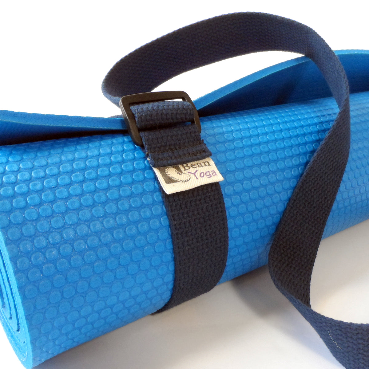 Blue yoga mat held by black cotton sling strap with secure adjustable loop design