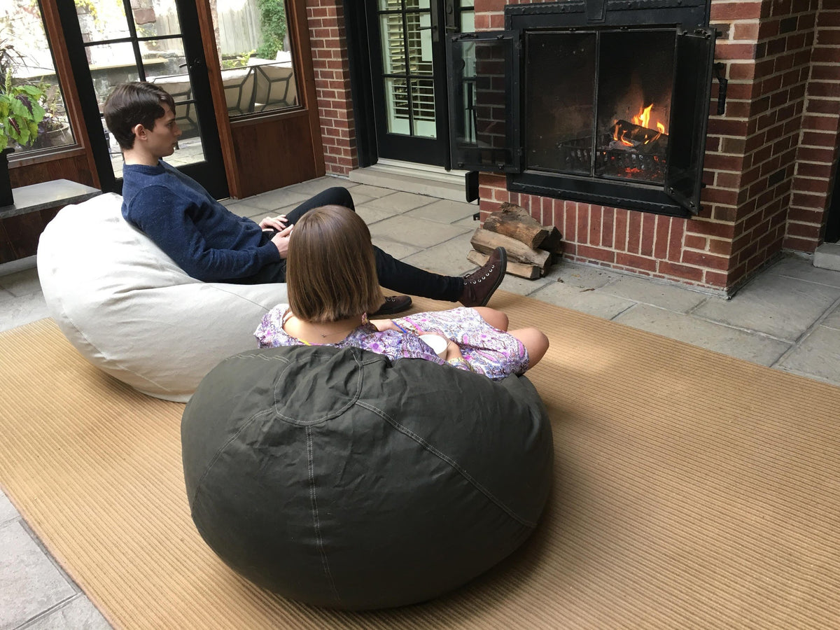 Child sitting on ComfyBean adult bean bag lounger in a modern living room setting