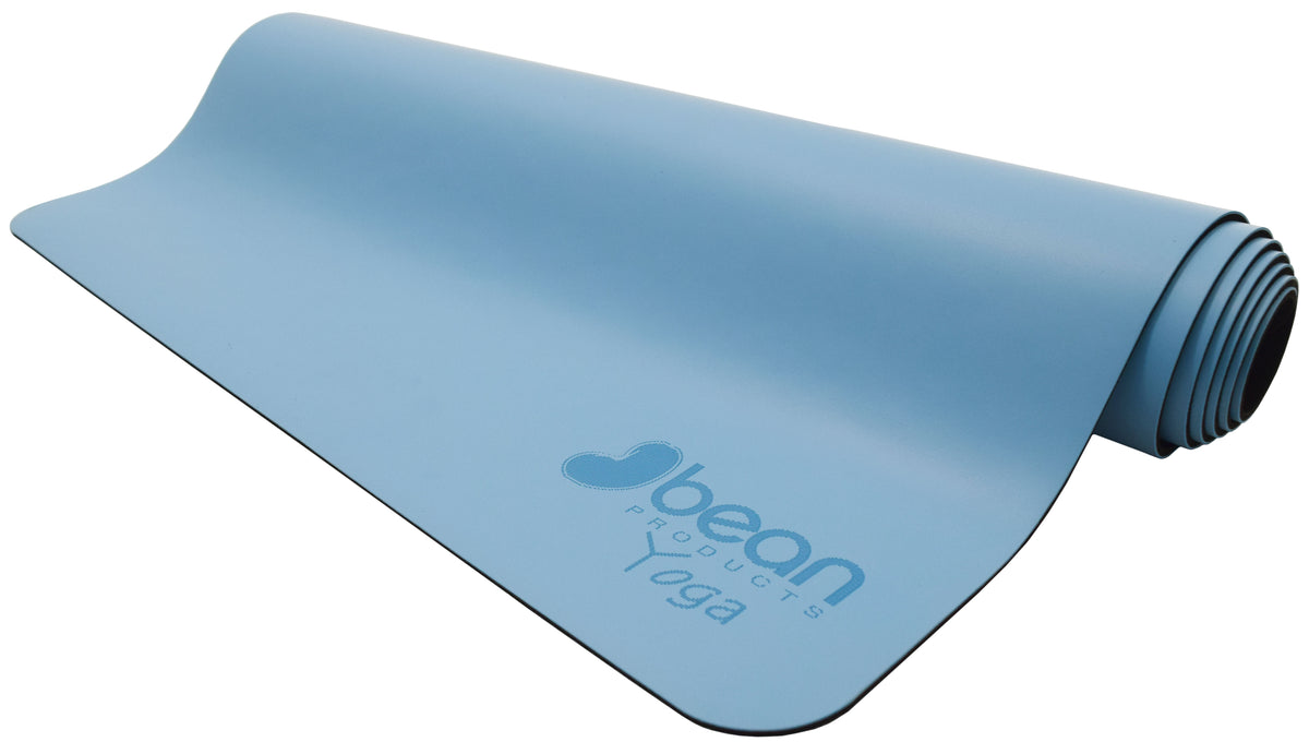 Rolled blue non-slip yoga mat showing thickness and textured surface
