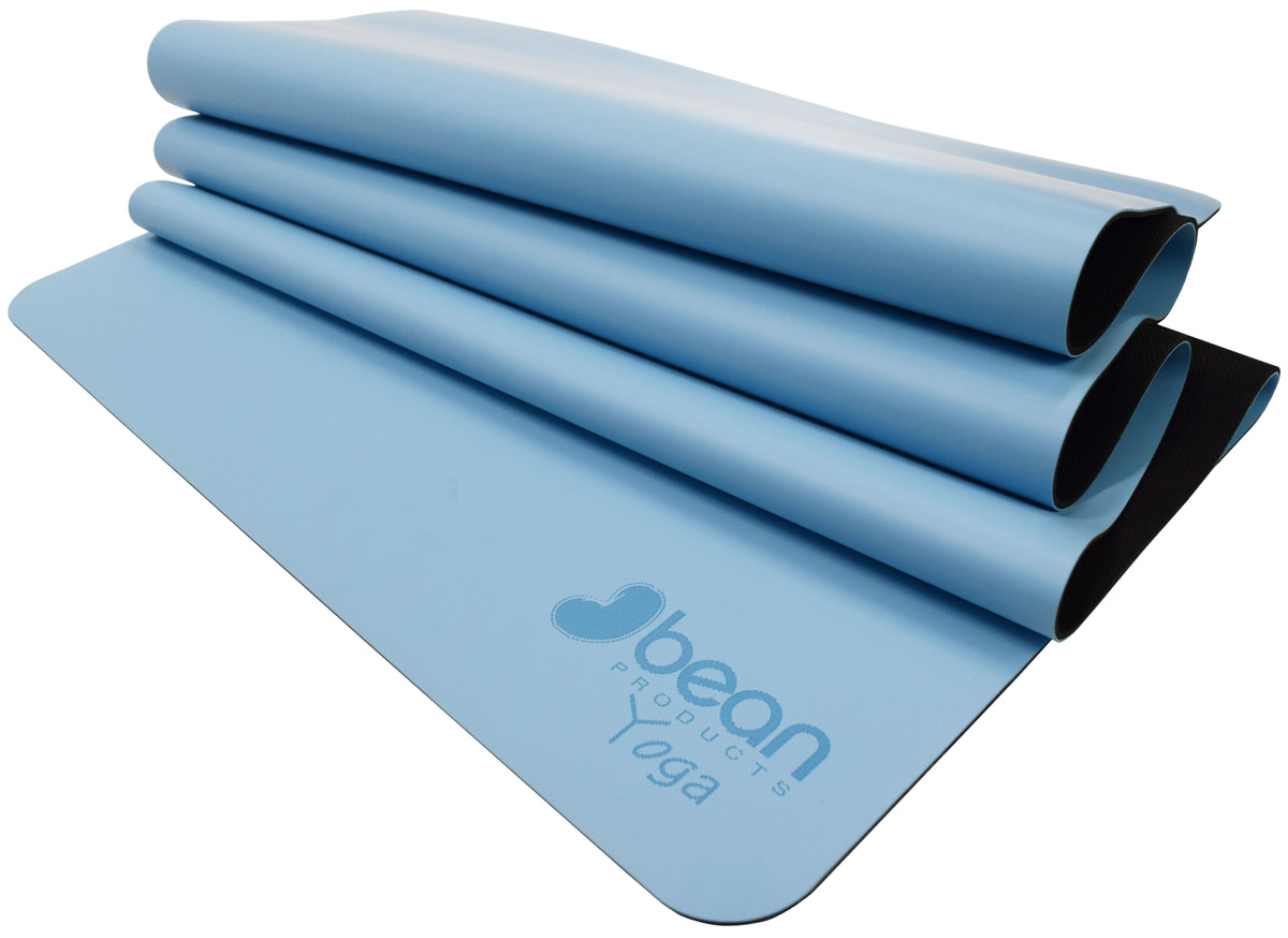 Folded blue non-slip yoga mat showing flexibility and durability