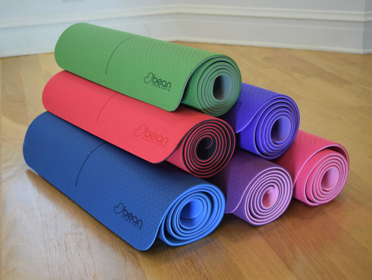 Stack of rolled multicolor yoga mats showing portability and compact storage